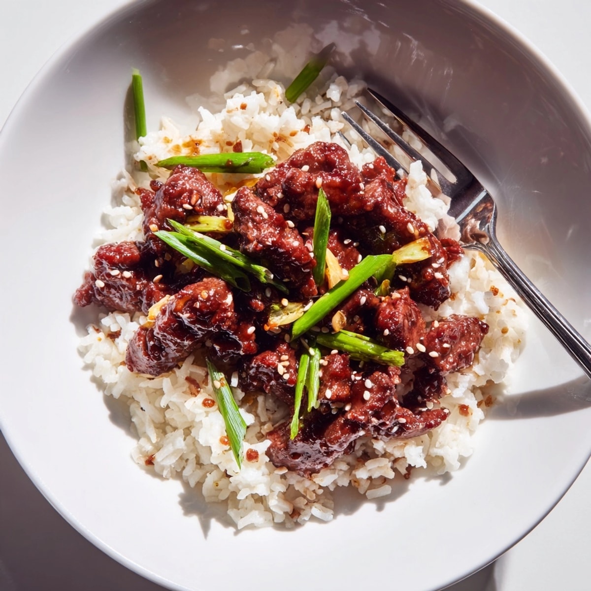 Homemade Mongolian Beef Stir Fry: Sizzling steak in rich sauce, served over rice.