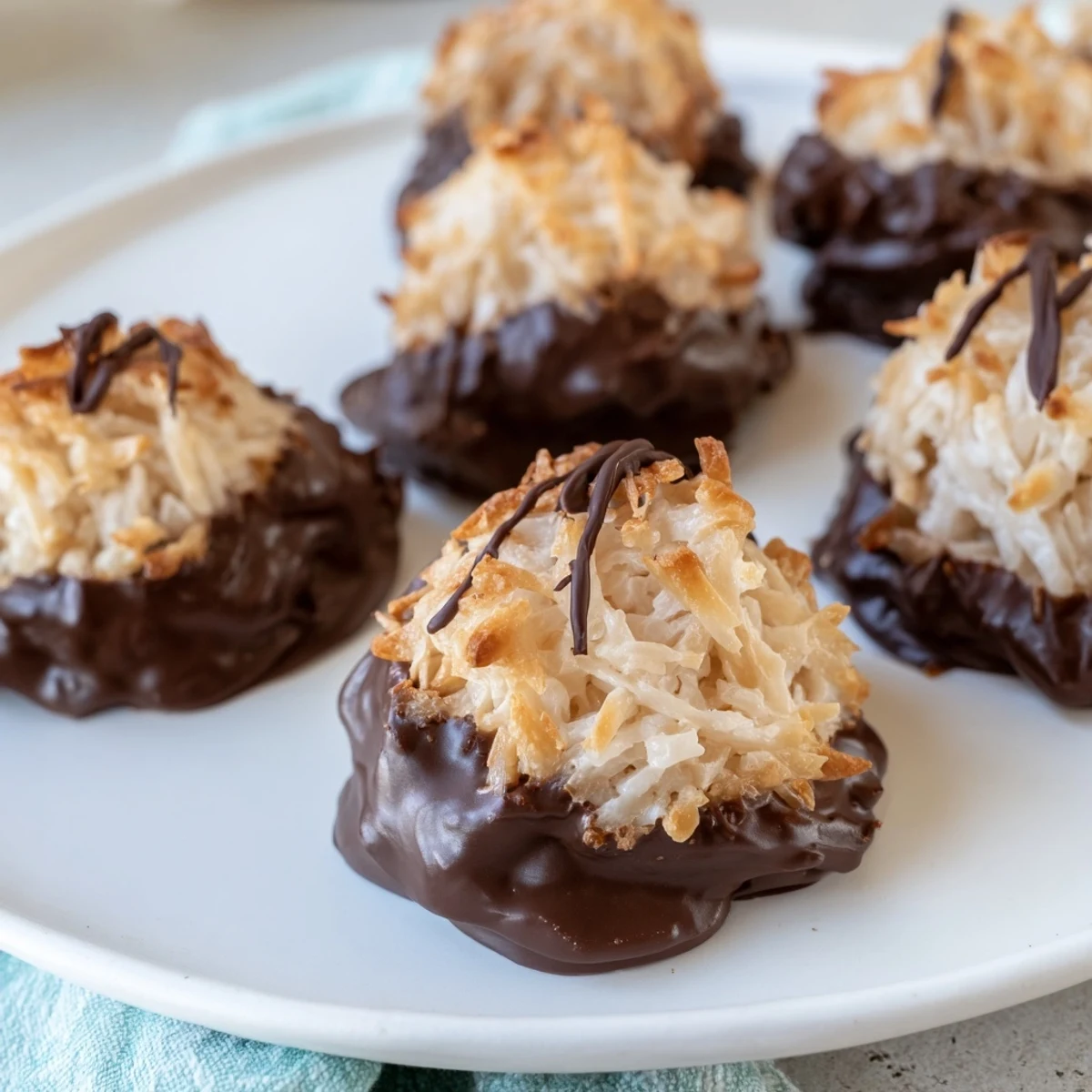 Golden-edged chocolate covered coconut macaroons, tempting and ready to be enjoyed as a sweet treat.
