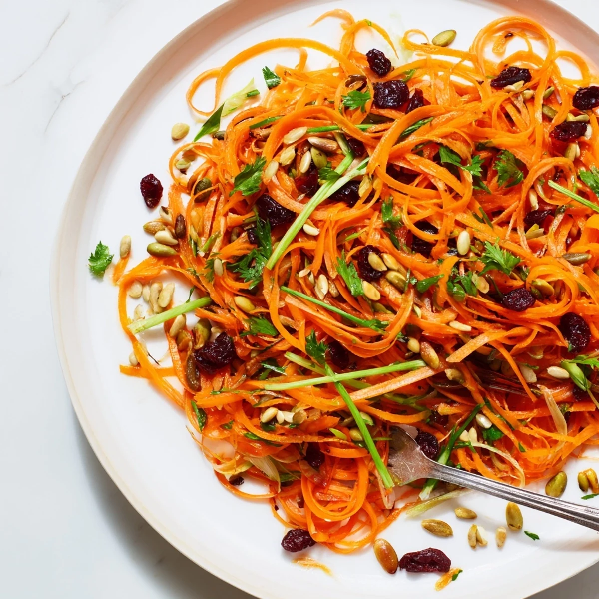 Freshly grated carrots with bright dressing featured in a beautiful Raw Carrot Salad, ready to eat.