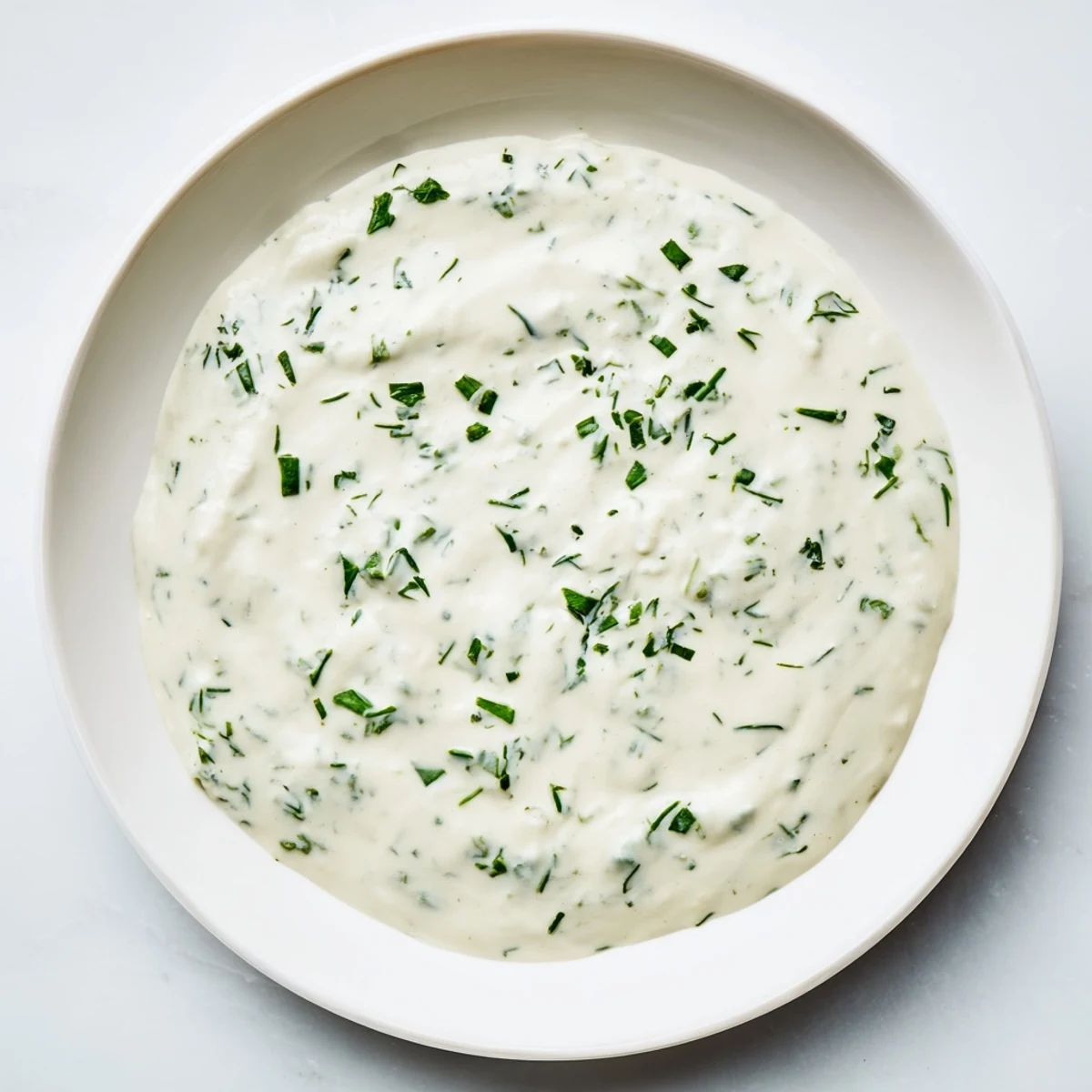 Freshly made Creamy Herb Dip, a smooth and creamy appetizer showcasing visible flecks of fresh herbs.