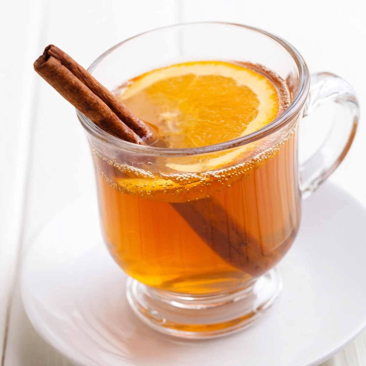 Golden-hued, spiced warm apple cider with cloves, garnished with orange slices; so inviting and aromatic.