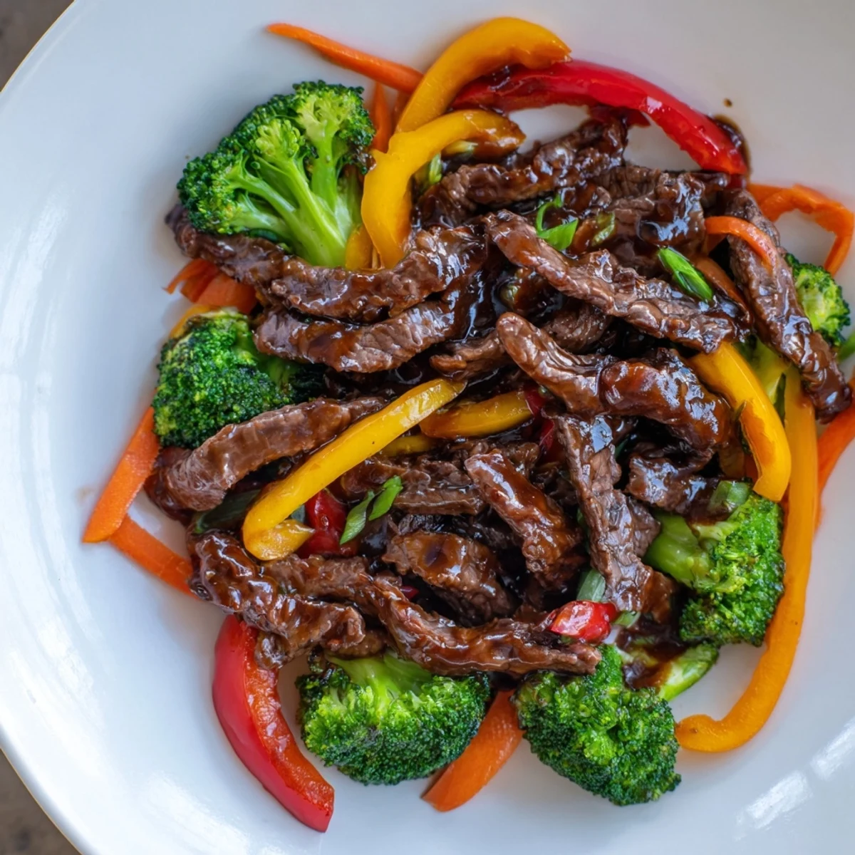 Vibrant beef stir fry with glistening sauce and steamed rice, a flavorful Asian-inspired meal.