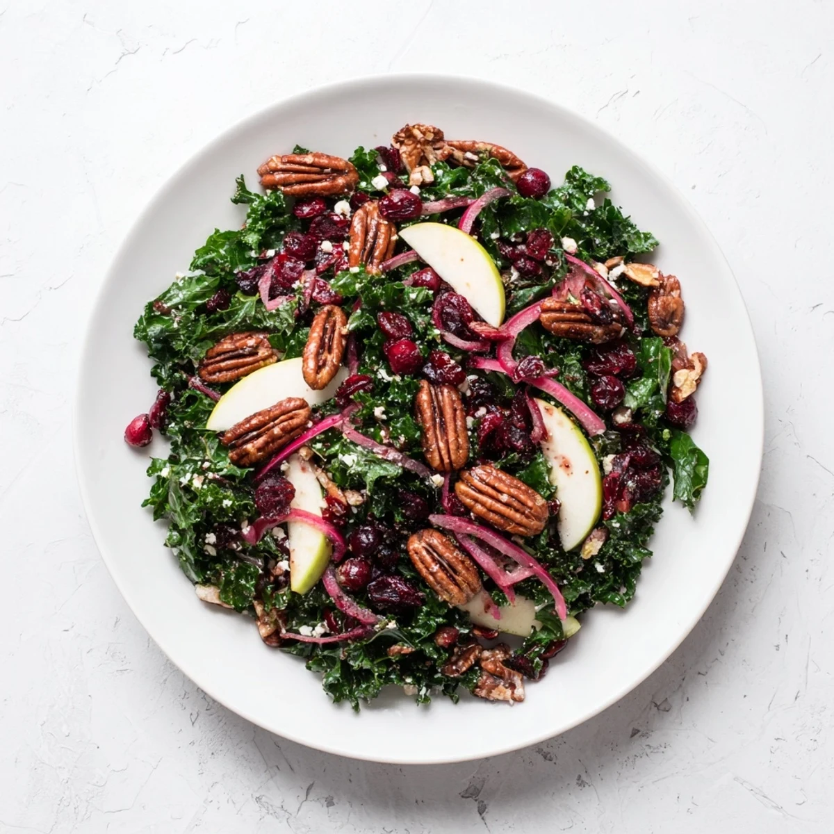 Vibrant Winter Kale Salad with pecans and cranberries, tossed with a tangy maple-Dijon vinaigrette, ready to serve.
