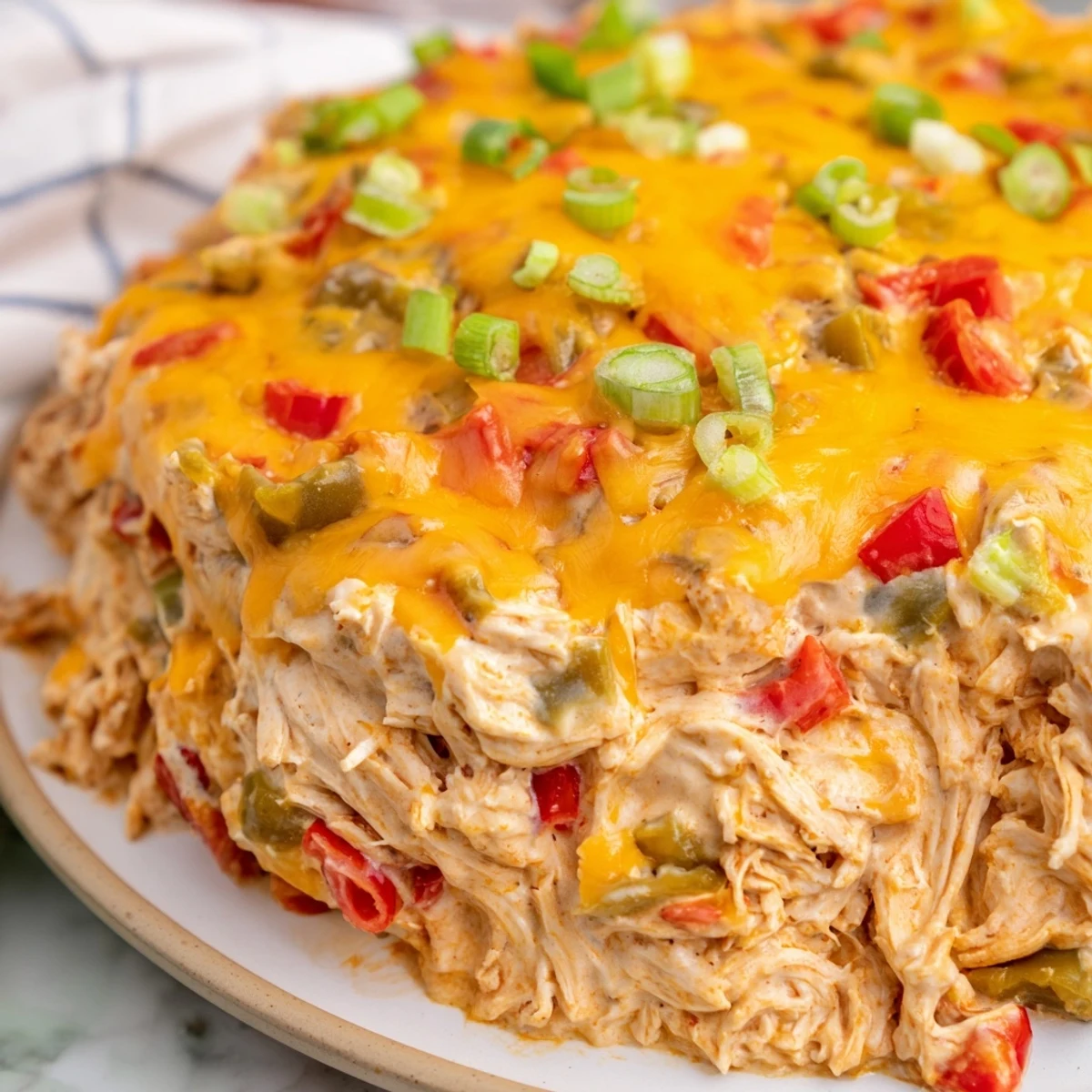 A bubbling pan of Chicken Enchilada Dip with Melted Cheese, garnished with fresh cilantro and served with crunchy tortilla chips.
