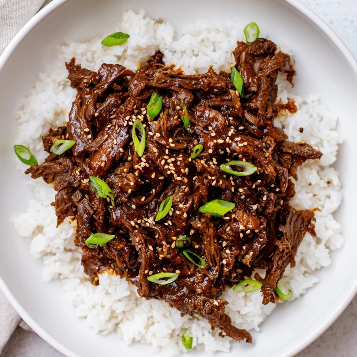 Garnished with green onions and sesame seeds, this Slow Cooker Korean Beef fills the kitchen with rich, aromatic Korean flavors.