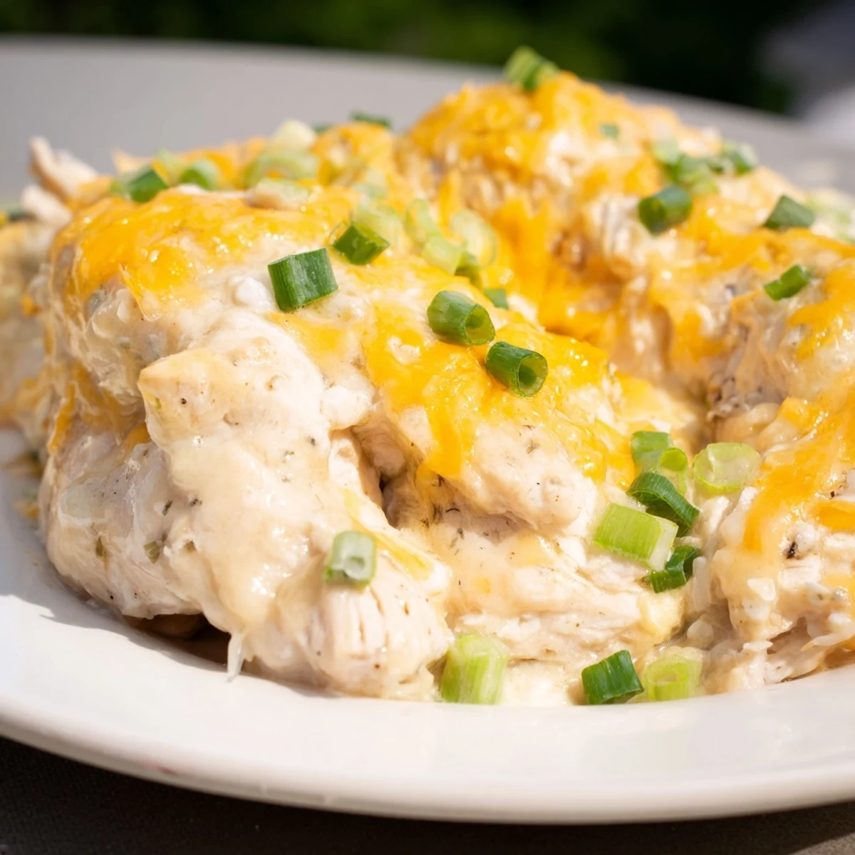 Golden-brown Sour Cream and Onion Chicken emerges from the oven with a bubbling, creamy cheddar topping, perfect for serving alongside steamed broccoli.