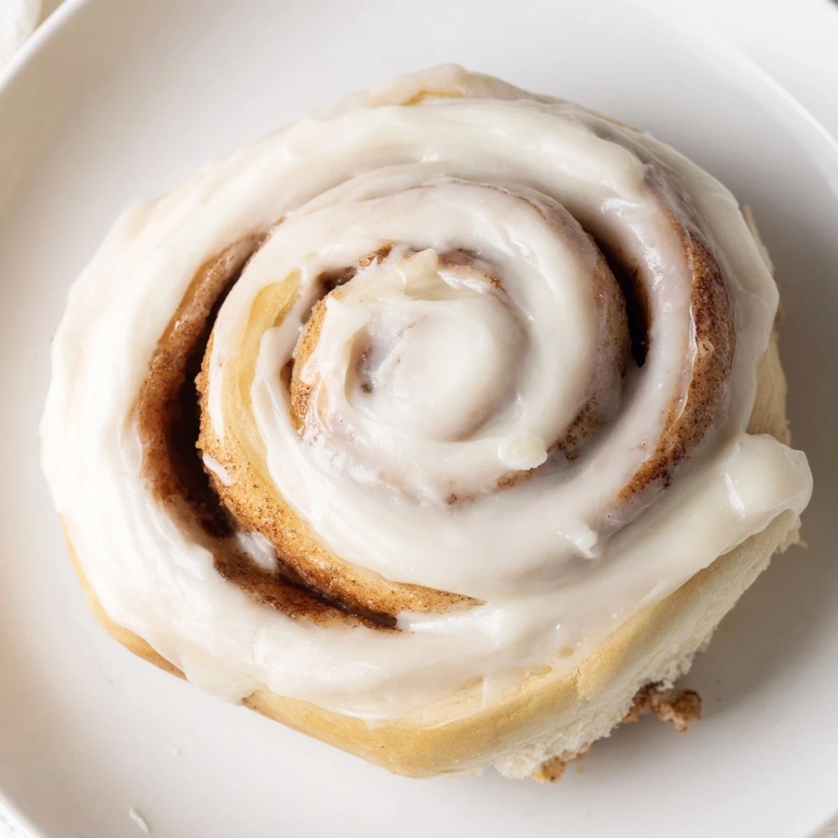 Freshly baked Keto Cinnamon Buns display a gooey cinnamon swirl and golden-brown edges in close-up.