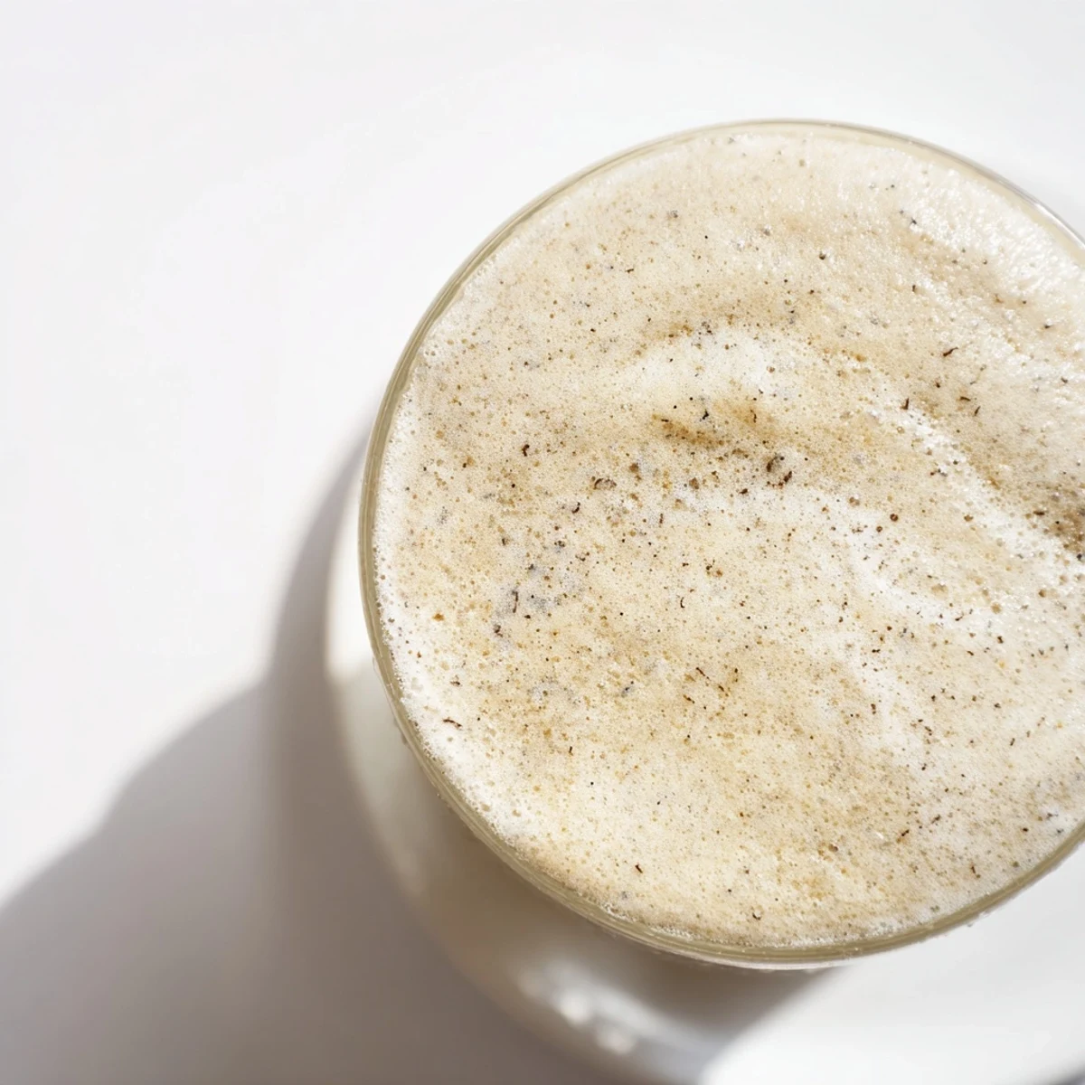 This homemade Vanilla Bean Frappuccino shows a frosty blended beverage with ice crystals and a straw ready to sip.