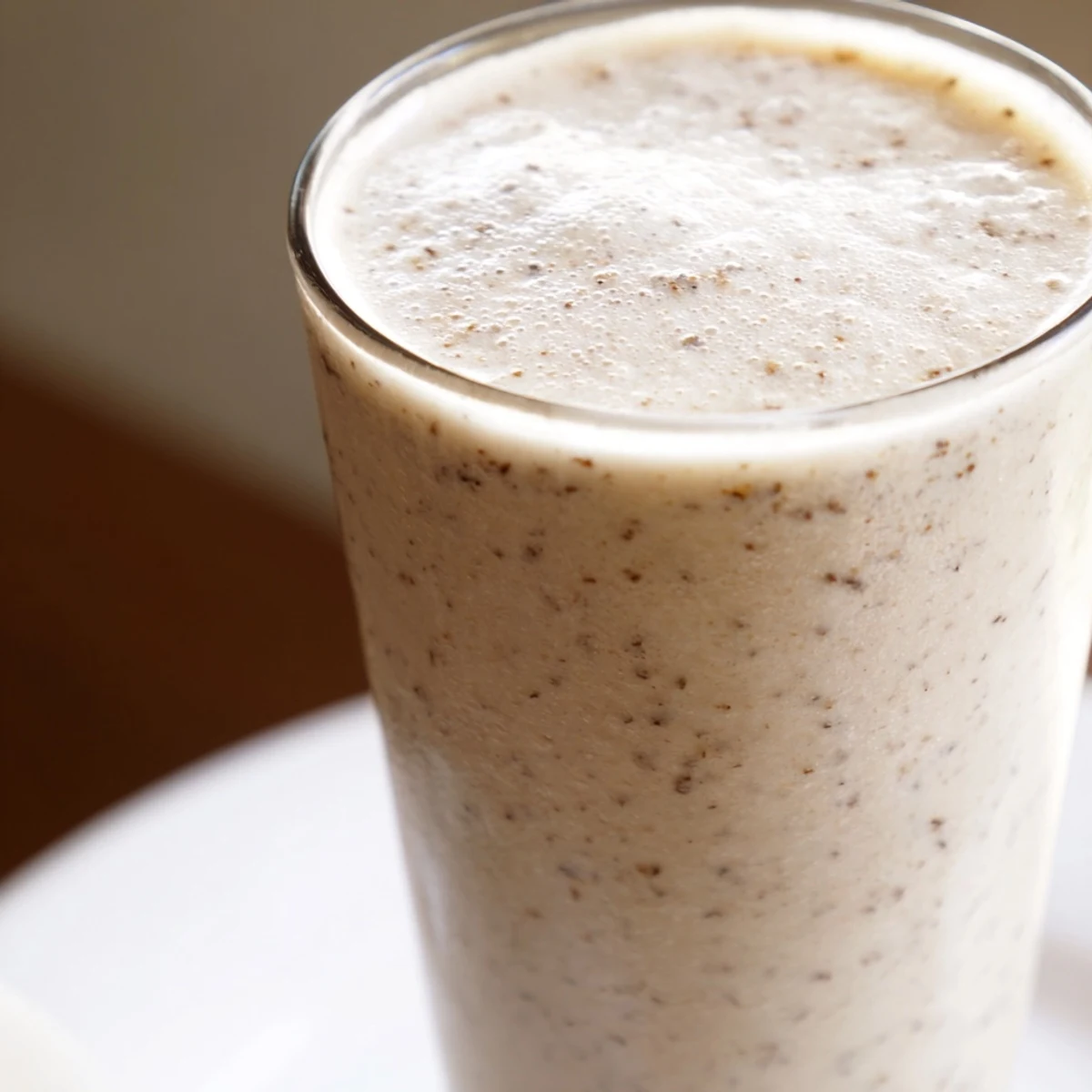 Vanilla Bean Frappuccino served in a tall glass with a swirl of whipped cream and visible vanilla bean specks.