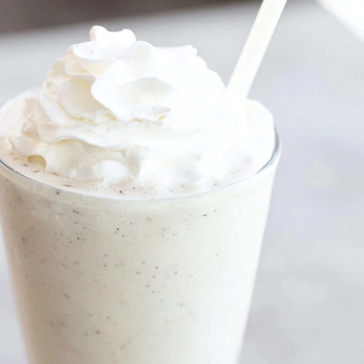 Homemade Starbucks Vanilla Bean Frappuccino served in a tall glass, blending ice, milk, and sweet vanilla ice cream.