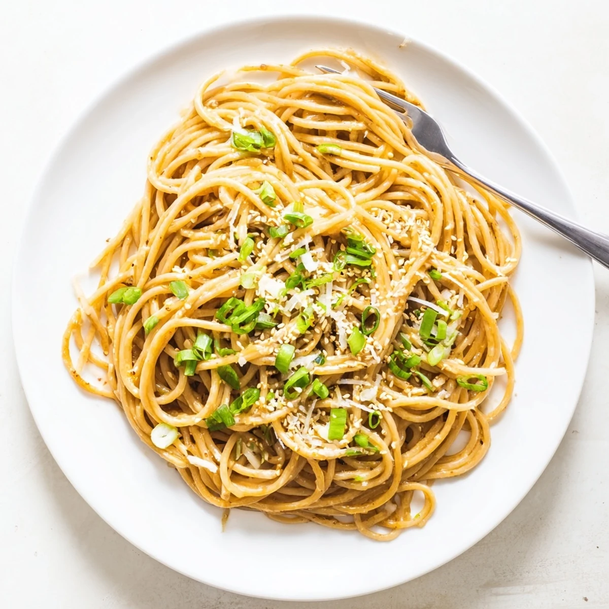 Fork-tender garlic noodles glisten with rich sauce and toasted sesame seeds garnish.