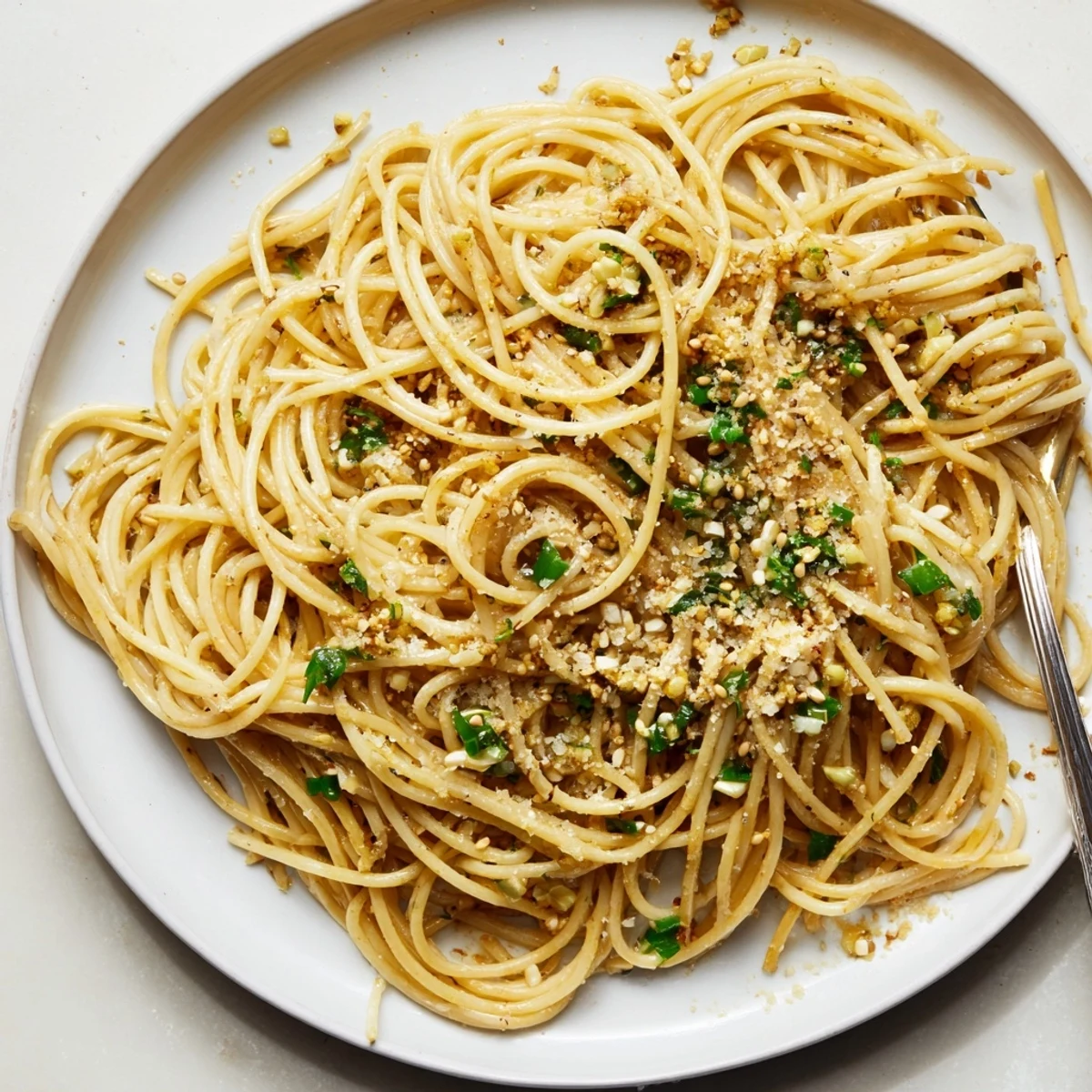 Quick homemade garlic noodles plated with Parmesan cheese and scallions for dinner.