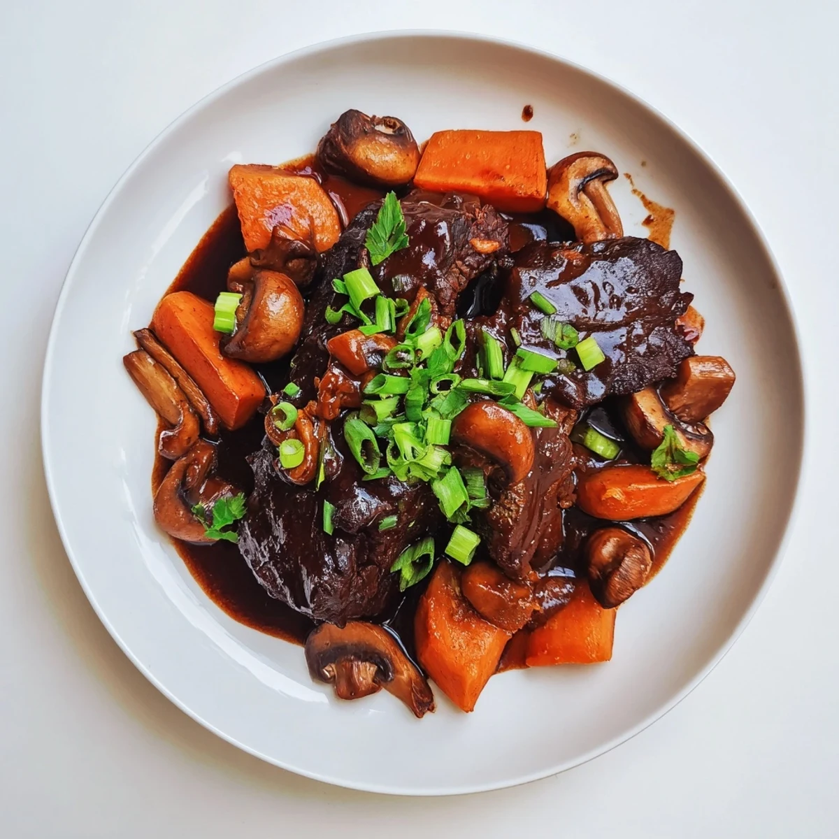 Asian Style Slow Cooked Beef Cheeks With Mushrooms served in a rustic pot with tender carrots and earthy mushrooms visible in the savory broth.