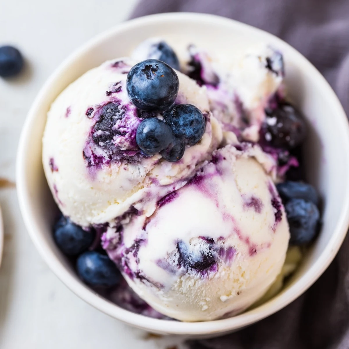 A close-up of homemade Blueberry Cottage Cheese Ice Cream topped with a drizzle of honey.