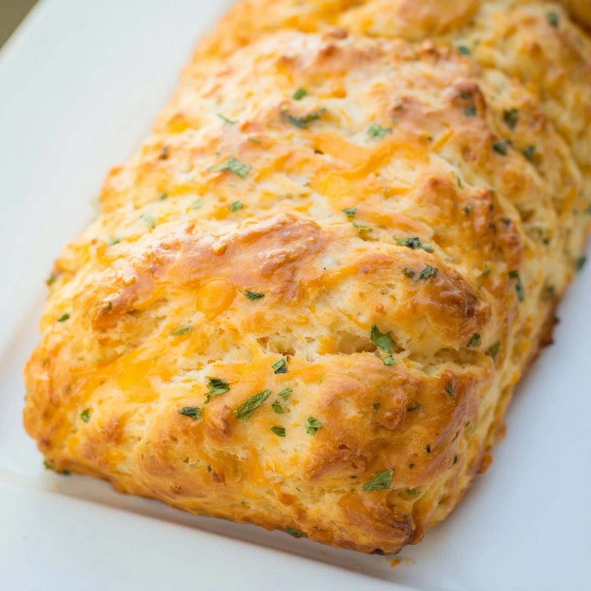 Sliced Red Lobsters Cheddar Bay Biscuit Loaf reveals a fluffy interior loaded with sharp cheddar cheese and herbs.
