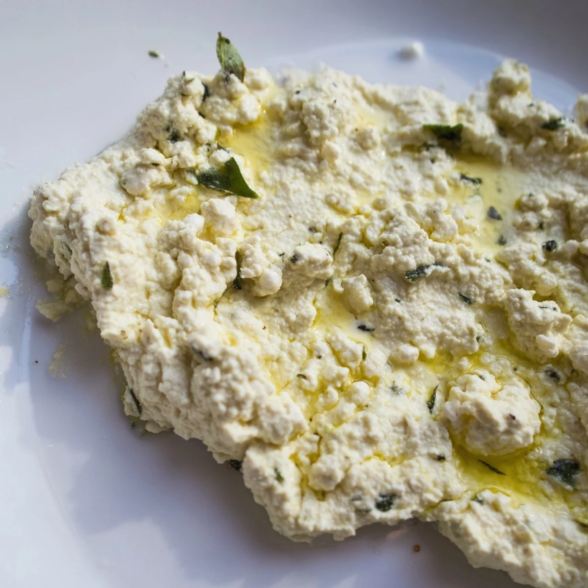 Creamy Tofu Ricotta with fresh basil leaves and a lemon wedge garnish for vegan lasagna.