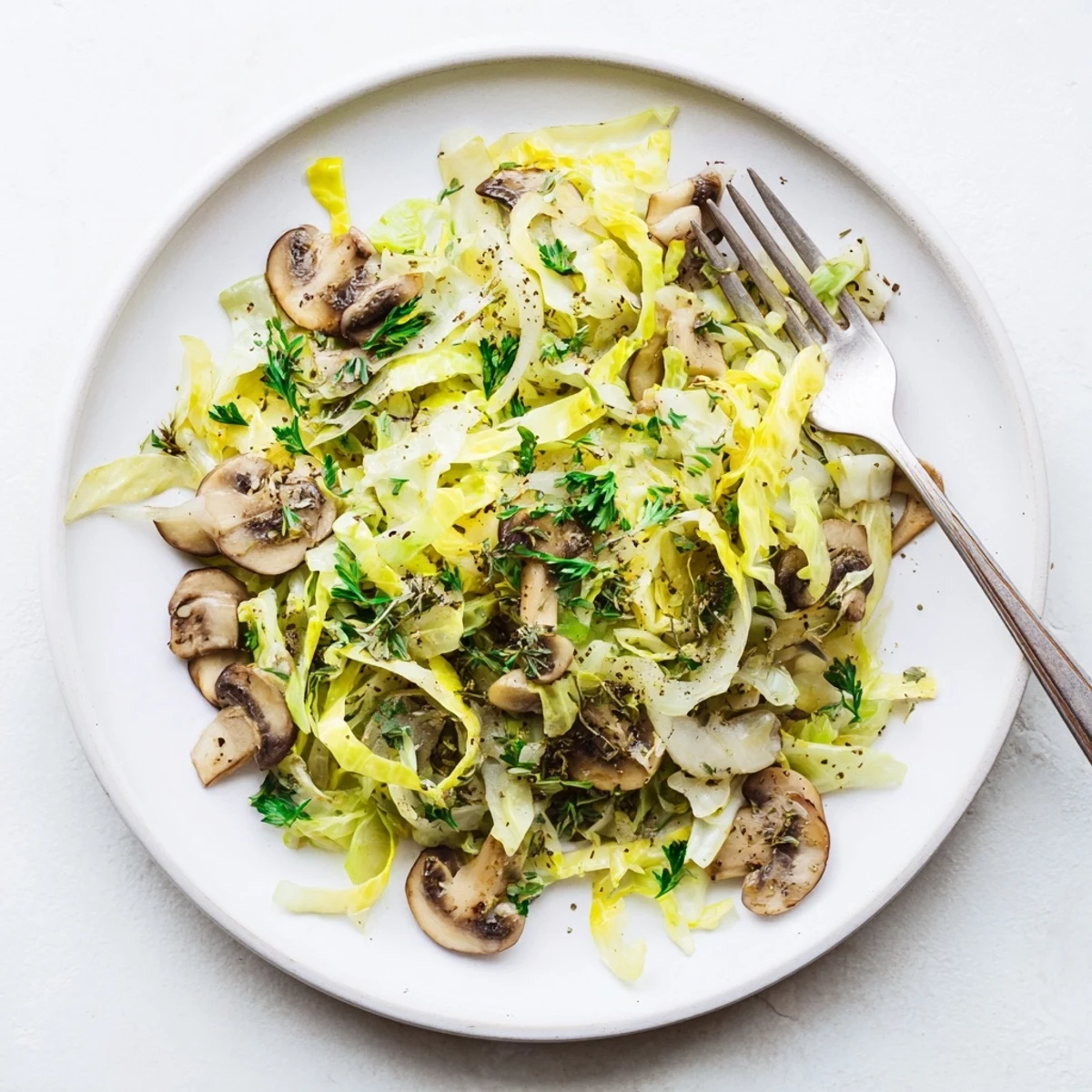 Fork-ready Vegetarian Cabbage Mushroom Sauté served over steamed brown rice, garnished with fresh parsley and a hint of lemon.