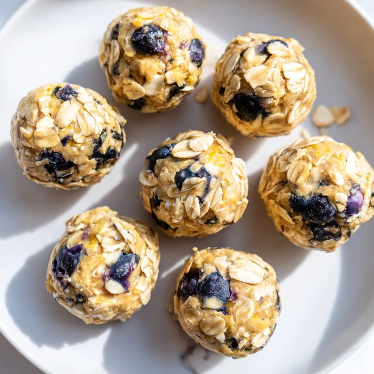 Close-up view of Blueberry Cheesecake Protein Bites showing a soft, chewy texture with vibrant blueberries and lemon zest.