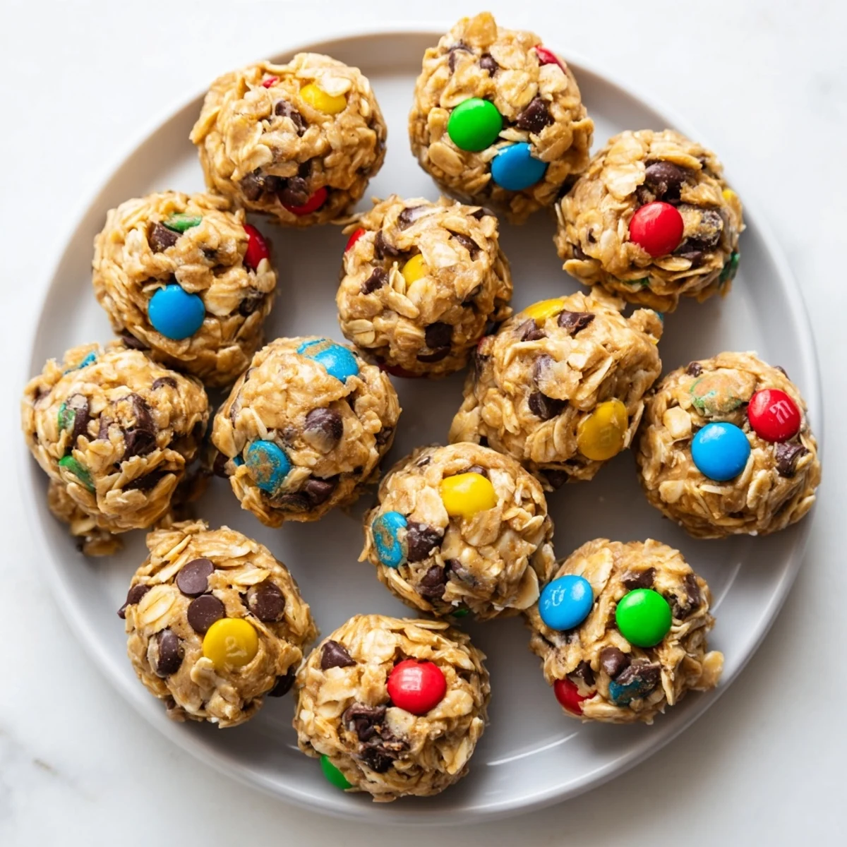 Homemade Monster Cookie Protein Balls on a rustic wooden board with a glass of milk for a wholesome treat.