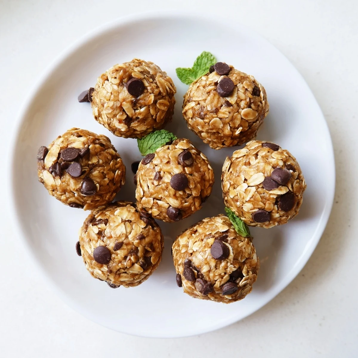Cool mint and chocolate chips shine in these no-bake Mint Chocolate Chip Protein Balls, arranged neatly on a tray.