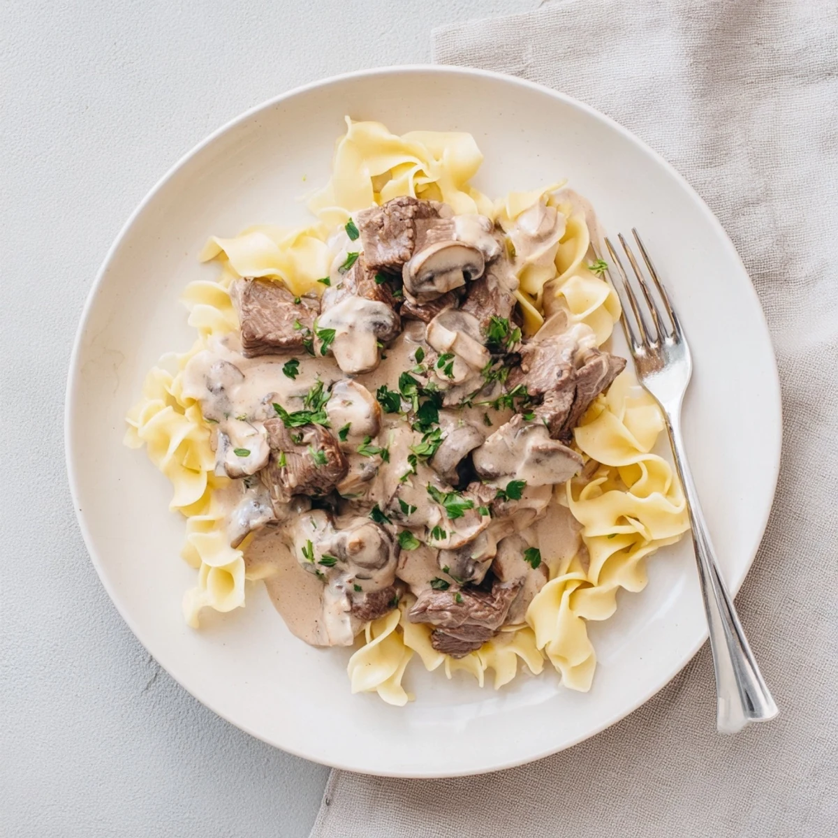 Golden egg noodles topped with savory beef and mushroom stroganoff in a velvety white sauce