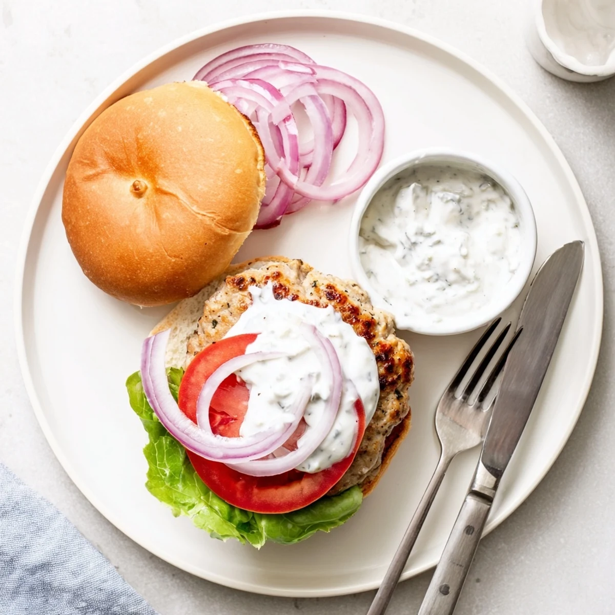 Succulent Mediterranean chicken patties grilled perfectly with melted feta and cool yogurt cucumber sauce