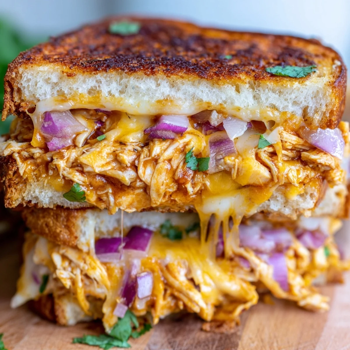 Crispy sourdough grilled cheese stuffed with BBQ chicken and colorful red onion slices