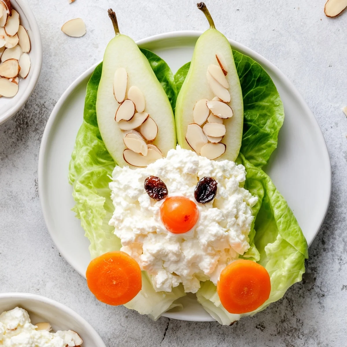 Retro-style pear bunny salad decorated with sliced almonds, fresh carrot details, and maraschino cherry noses for festive spring occasions