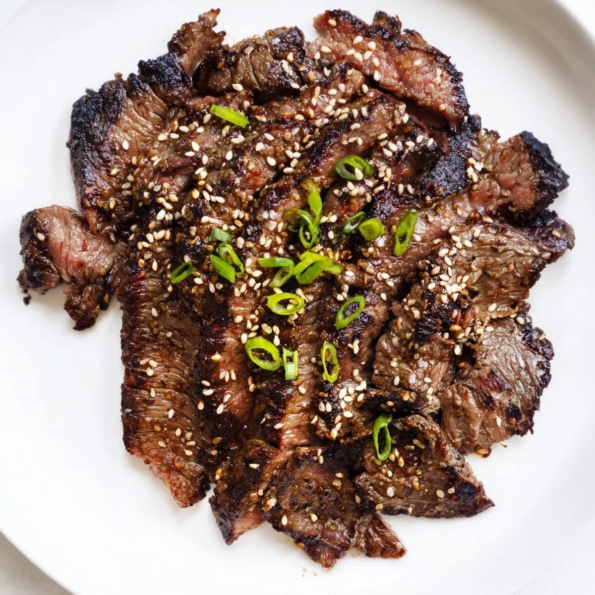 Sizzling Beef Yakiniku with caramelized edges served alongside charred vegetables and fluffy steamed white rice