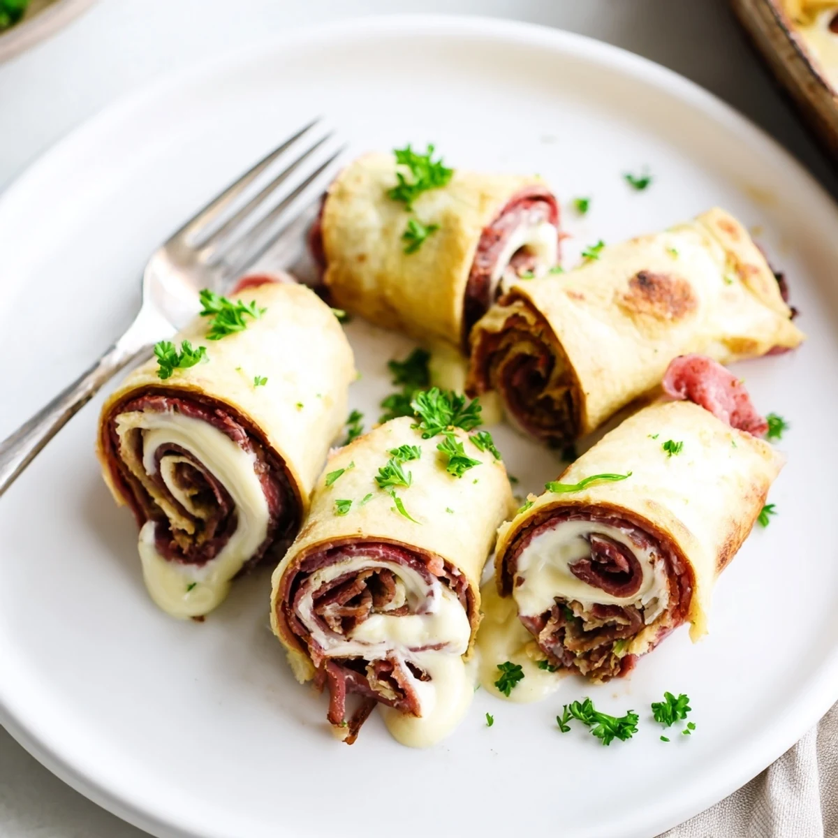 Golden Low Carb Reuben Egg Roll Ups filled with melty Swiss cheese and tangy sauerkraut