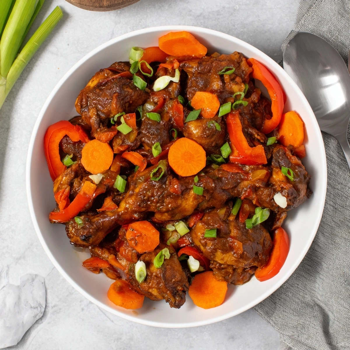 Juicy Jamaican brown stew chicken with colorful bell peppers in a thick savory sauce