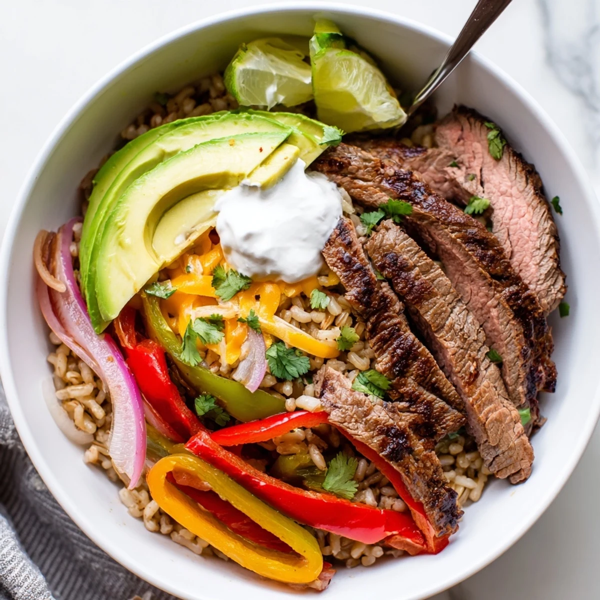 Steak Fajita Power Bowls with sizzling marinated steak, colorful peppers, lime wedge