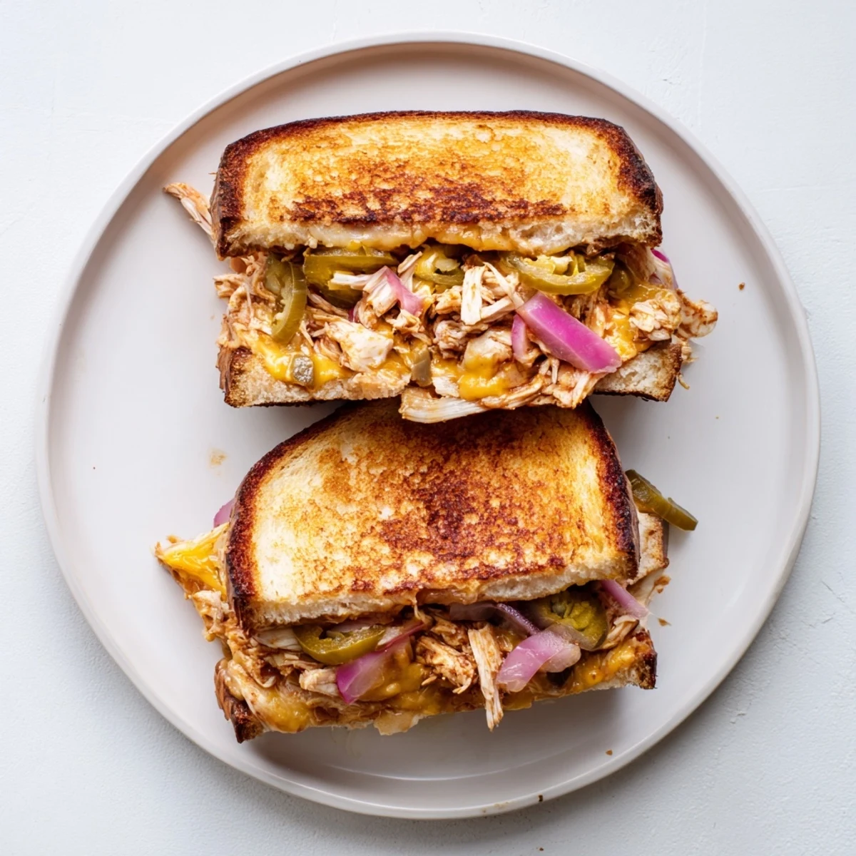 Crispy sourdough BBQ chicken grilled cheese with sharp cheddar and mozzarella layers