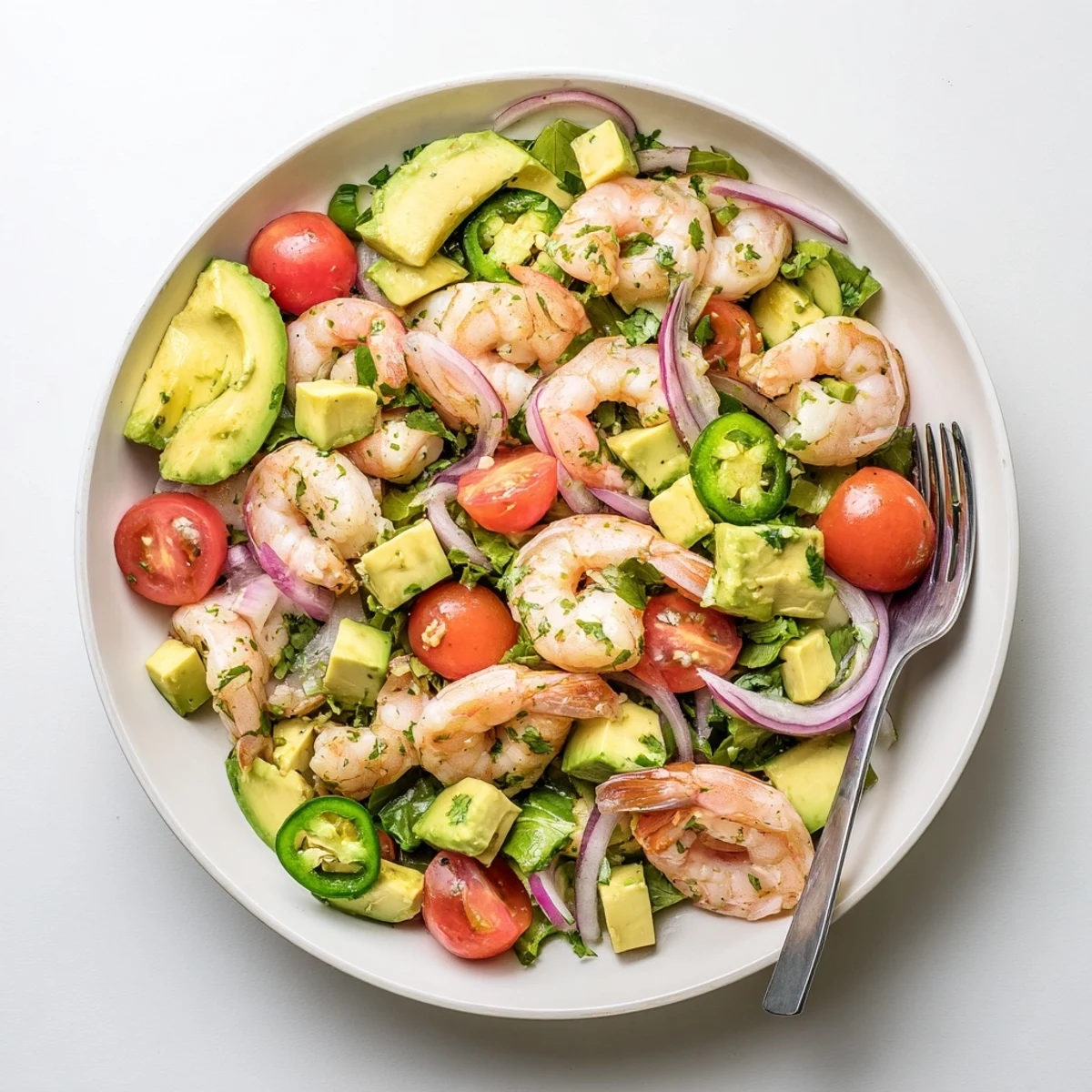 Vibrant shrimp avocado salad recipe plated with juicy tomatoes, cucumber slices, and lime drizzle