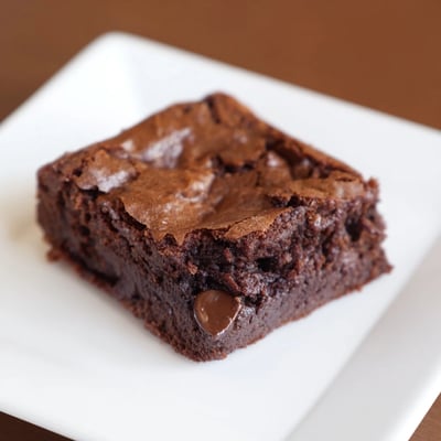 Warm, freshly baked chocolate brownies with a crackly top, a delightful dessert treat.