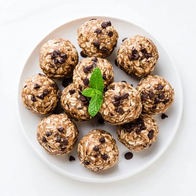A refreshing post-workout snack, these Mint Chocolate Chip Protein Balls are ready to enjoy on a marble platter.