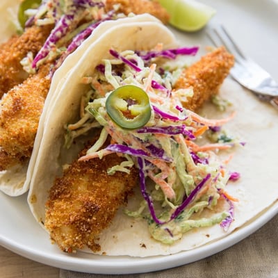 Close up of Crispy Fish Tacos with Cilantro Lime Slaw filled with golden fish and fresh slaw