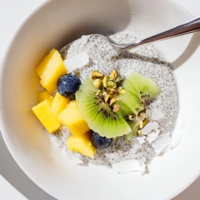Glass jars of Coconut Chia Pudding chilled overnight, garnished with berries