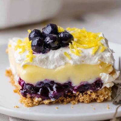 Chilled Lemon Blueberry Lasagna Recipe topped with whipped cream, zesty lemon and berries